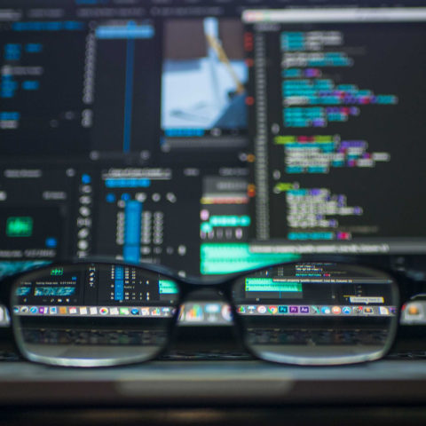 Computer Screens with Code Seen Through Glasses
